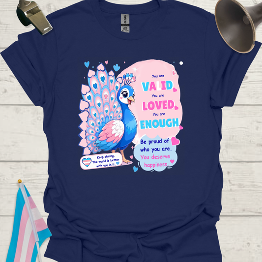 Navy blue t-shirt with a peacock graphic and motivational text on a wooden surface.